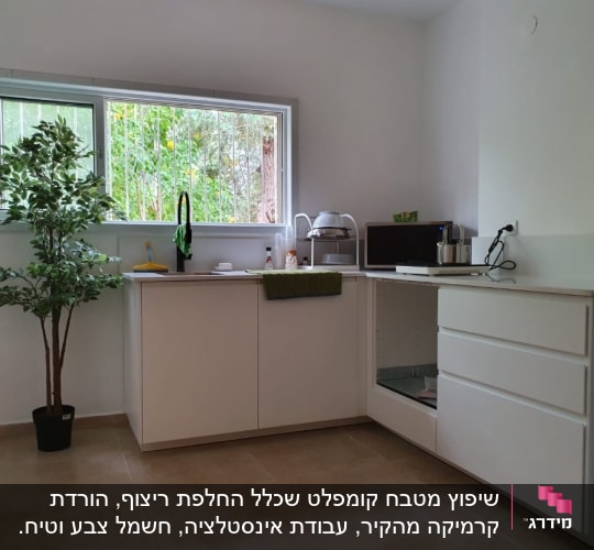 מטבח משופץ עם ארונות לבנים וכיור חדש